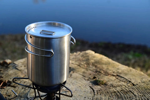 Stainless Steel Canteen Water Bottle With Nested Camping Cup and Lid wide mouth 40oz on stump by lake, ideal for bushcraft gear