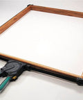 One-Hand Ratcheting Band Clamp For Quick Glue-Ups And Framing, 16-Inch Clamp With Self-Adjusting Corners in use on a wooden frame