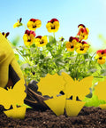 Ultra Thick Yellow Sticky Traps For Fruit Flies And Fungus Gnats With 48 Pack set among colorful flowers in a garden.