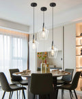 Modern Black And Gold Glass Pendant Light 2 Pack With Adjustable Height Cord For Kitchen Island Clear Round Shade E26 Socket overhead in dining area.