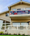 250th Anniversary USA Banner Flag 120 Inch Premium Polyester With Brass Grommets displayed on house porch celebrating independence.