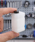 Clear 120CC RC Plane Fuel Tank Set With Metal Tubing And Engine Container held in hand, showcasing compact size.