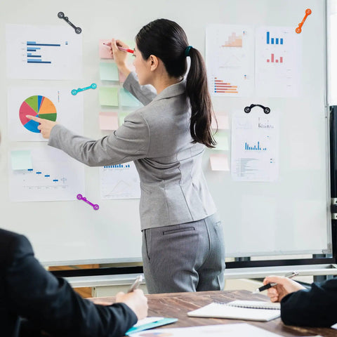 Woman using Magnetic Cable Clips Set Of 12 for Cable Management and Organization on whiteboard with charts and post-its.