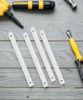 Four white rails from Three Pack Plastic Drawer Slides For Cabinets And Cupboards, Easy Install, Smooth Quiet Performance, White Rails With Fasteners, Ideal For Containers, Dressers, Small Cabinets, And DIY Storage Drawers on wooden surface near tools