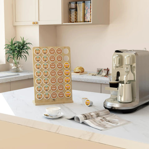 Bamboo K Cup Holder Storage Organizer holds 35 coffee pods for countertops in coffee bars offices and kitchens beside a coffee machine.