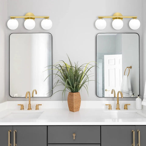 Rock A Stylish Mid Century Modern Vibe In Your Bathroom With These Three Light Gold Vanity Fixtures Complete With Frosted Milk Glass Globes And A Brushed Gold Frame That Is Dimmable Wall Mount Ready above a double sink with plants and mirrors