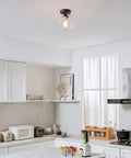 Harrow 1 Light Semi-Flush Mount Ceiling Light With Matte Black Finish, Gold Accent Socket, Clear Glass Shade in a kitchen setting