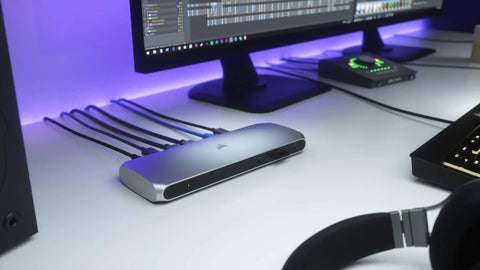 Thunderbolt 3 Dock For Laptop Users Delivers Snazzy Desk Setups With 85W Fast Charging, showing a sleek silver docking station on a workspace.