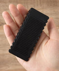 Rock Solid Black Rubber Wedge Shims For Furniture Leveling Hella Sturdy Anti Slip Wobble Pads To Smooth Uneven Floors And Zero Shake Universal Cabinet Stabilizers held in hand.
