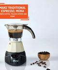 Dang Compact Two Cup Electric Espresso Maker With Cool Touch Handle brews coffee on a sleek countertop with coffee beans nearby.