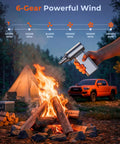 High Power Electric Air Duster With 150000 RPM Turbo Fan And 6 Adjustable Speeds used outdoors near a campfire.
