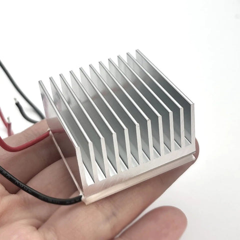 4 Pack Anodized Aluminum Heat Sinks 40 By 40 By 20mm Kit held in hand, showing aluminum fins for passive cooling of electronics.