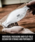 Hands holding a Lightweight N95 Particulate Respirator With 3 Panel Design in individual packaging, ready for use.