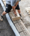 Man using Versa-Lok Versa Lifter Standard Tool for Easy And Safe Handling Of Block Walls while lifting concrete blocks.