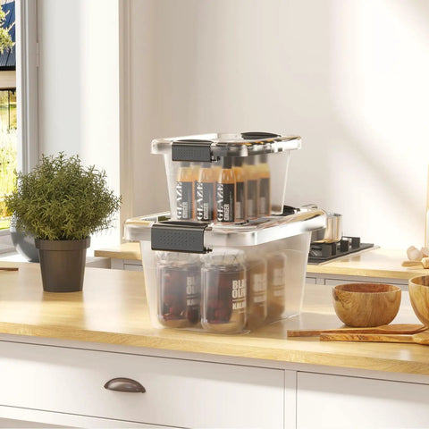 Stackable Plastic Storage Bins Set Clear 6 Quart Nestable Boxes With White Lids And Secure Latching Buckles 12 Pack Perfect For Pantry Toys Office And Garage Organization shown stacked on a kitchen counter containing bottles.