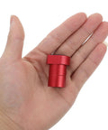 Hand holding a single red aluminum stopper from 8 Pack Woodworking Planing Stoppers For Workbench Dog Holes