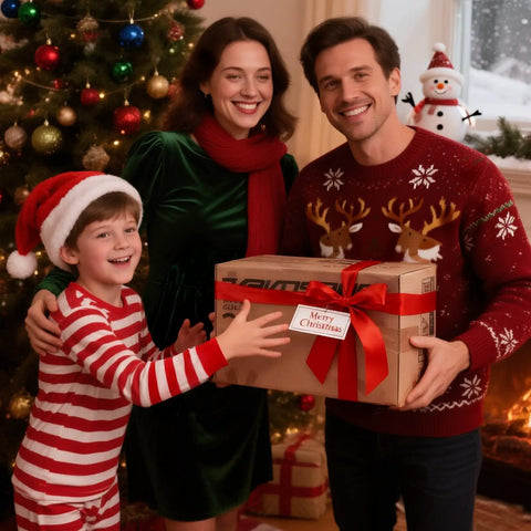 Family in festive attire holding a Christmas gift box with a red ribbon beside a decorated tree and snowman in the background.