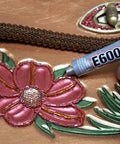 Craft Adhesive 4 Pack 0.18 Oz Tubes With Five Minute Open Time being applied to floral fabric embroidery.