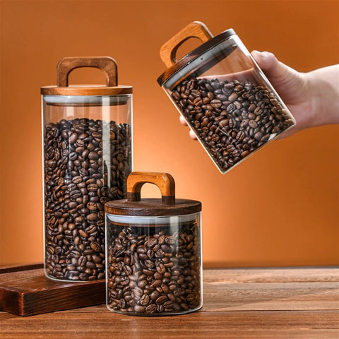 Premium Glass Coffee Canister With An Airtight Wooden Lid To Keep Your Daily Grind Fresh, storing coffee beans on a wooden counter.