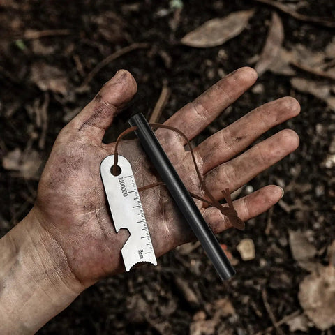 Hand holding 4 inch ferro rod with leather lanyard, multi tool striker, part of Two Pack 4 Inch Ferro Rod Fire Starter Kit