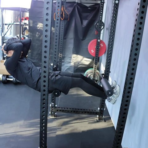 Person using Single Leg Squat Roller Attachment for Power Rack and Home Gym, Nordic Curls Kit, Bulgarian Split Squat Accessory