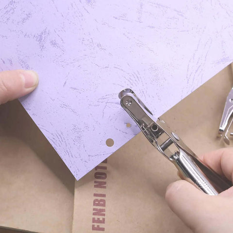 Dual Hole Punch Set With One Quarter Inch And One Eighth Inch Holes used on paper, ergonomic design shown in use