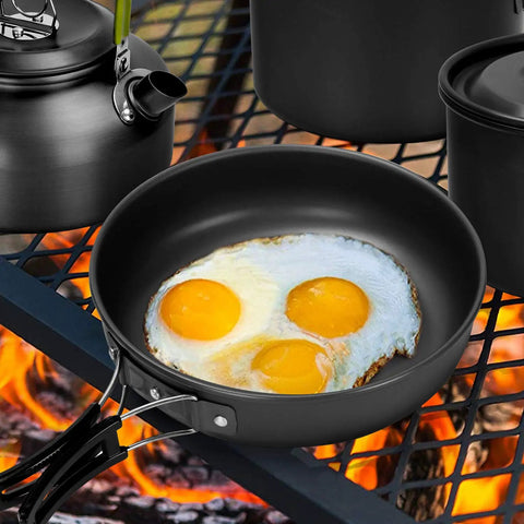 Go To Ultimate 29 Piece Camping Cookware Mess Kit with nonstick lightweight pan and eggs on grill over fire