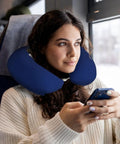 Woman using Maine State Flag Print U Shaped Travel Pillow With Memory Foam Cervical Support on a train, holding a phone