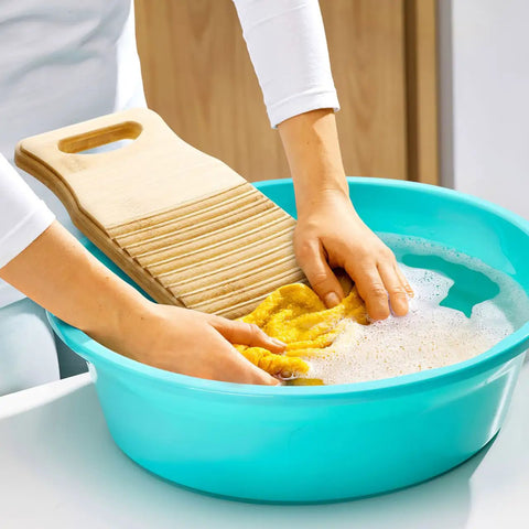 No Sweat Bamboo Washboard For Hand Washing Clothes With Non Slip Base and Deep Grooves being used in a blue basin.