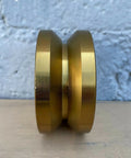 Badass 4 Inch Solid Gate Roller Wheel With Dual Bearing V Groove, Zinc Plated Gold Finish, side view showing design details.