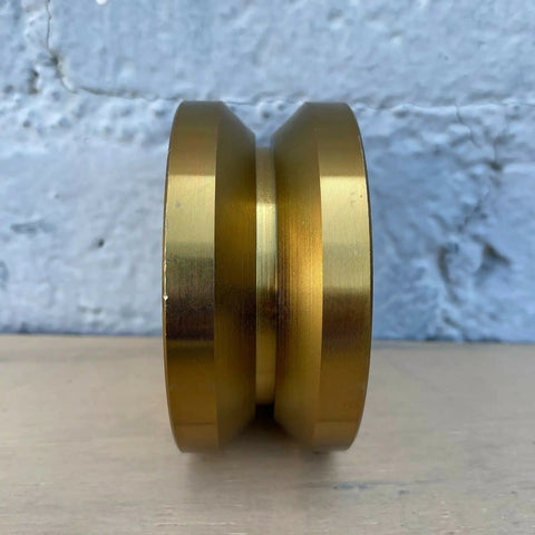 Badass 4 Inch Solid Gate Roller Wheel With Dual Bearing V Groove, Zinc Plated Gold Finish, side view showing design details.
