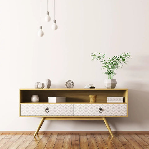 Mid-century modern sideboard with geometric pattern drawers, decorated with plants and ornaments in a minimalist room.