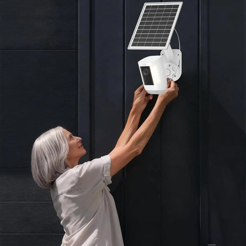 2 In 1 Solar Panel Wall Mount For Outdoor Security Camera With 7W Solar Charger on dark wall, woman adjusting camera