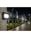 SODEF 50W LED Floodlight White Light IP65 Water-Resistant Outdoor High Lumen Energy Saving on a concrete wall illuminating a factory.