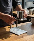 Minimalist Silver Finish Pour Over Coffee Dripper With Solid Metal Base compact setup in use on a wooden counter.