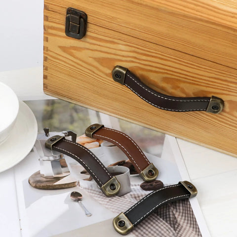 Leather Suitcase Luggage Pull Handles 2 Piece Set, black brown finish, on wooden cabinet with attached hardware, for doors and drawers