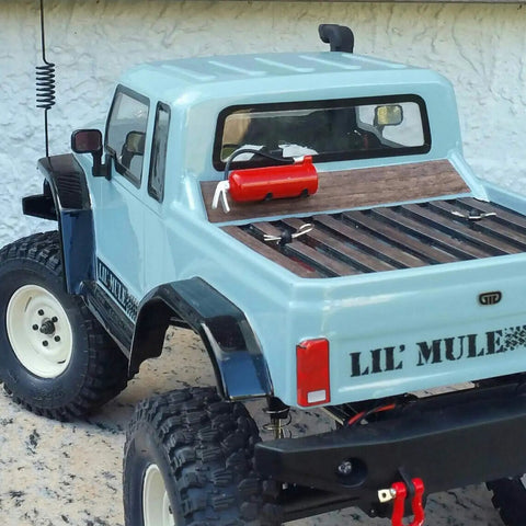 Rear view of RC car with 1 Pack Realistic Fire Extinguisher Decoration With Sticker For One Tenth Scale RC Rock Crawler Axial SCX10 RC Car And Truck Parts Lightweight And Easy To Install Adds Dope Showroom Style To Your Ride on the bed.