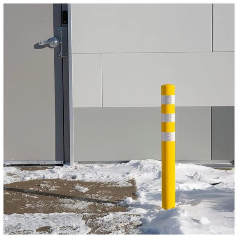 Real Deal Removable Safety Bollard 34.5 Inch Reflective Yellow Traffic Post in snow near building entrance.