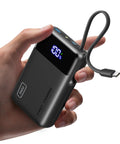 Hella Compact 20000mAh Power Bank With 45W Fast Charging in hand showing digital display and USB cable for convenient use.