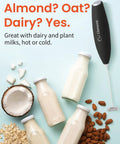 Black Handheld Milk Frother Wand With Stand, Turbo Electric Coffee Mixer next to milk bottles, nuts, and coconut