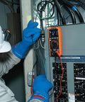 Rugged Digital Multimeter With Auto-Ranging TRMS LoZ Ghost Voltage Elimination in use on electrical panel by technician.