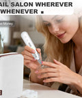 Woman using Cordless Electric Nail File Drill With Rugged 2000 Mah Battery And Bright Led Lamp for manicure at home.