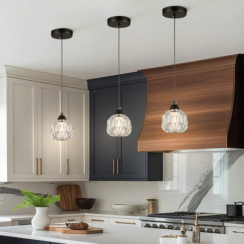 Three Light Matte Black Pendant Lighting With Transparent Glass Shades hanging in a kitchen over island