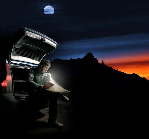 Person using Ultra Compact Mini Incandescent Flashlight With Twist Focus Beam to read map at night by car.