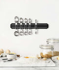 Magnetic Stainless Steel Measuring Spoons Set 8 Pieces With Leveler mounted on kitchen wall, surrounded by baking ingredients.