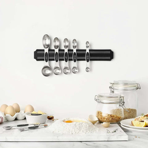 Magnetic Stainless Steel Measuring Spoons Set 8 Pieces With Leveler mounted on kitchen wall, surrounded by baking ingredients.