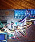 PCA9685 16 Channel 12 Bit PWM Servo Driver Board with I2C interface connected to microcontroller and display, on a wooden surface