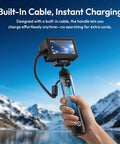 Person holding 10000mAh Battery Grip For Cameras With Hidden 360 Degree Tripod Base near snowy mountains, built-in cable visible.