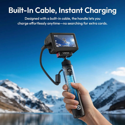 Person holding 10000mAh Battery Grip For Cameras With Hidden 360 Degree Tripod Base near snowy mountains, built-in cable visible.