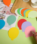 Person decorating 360 Die Cut Paper Balloon Cutouts 3.9 Inch Assorted Colors with pencils for classroom DIY crafts
